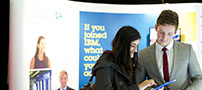 An undergraduate student at a recruitment fair, talking to an employee of IBM