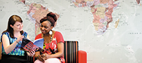 Two students looking through an information booklet in the International Office, Jubilee Campus