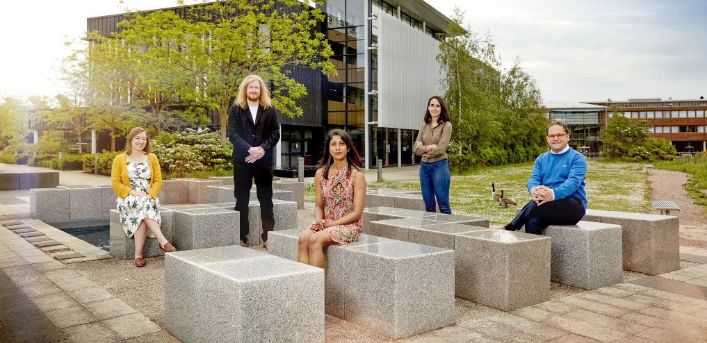 Five academics posing outside on Jubilee campus 