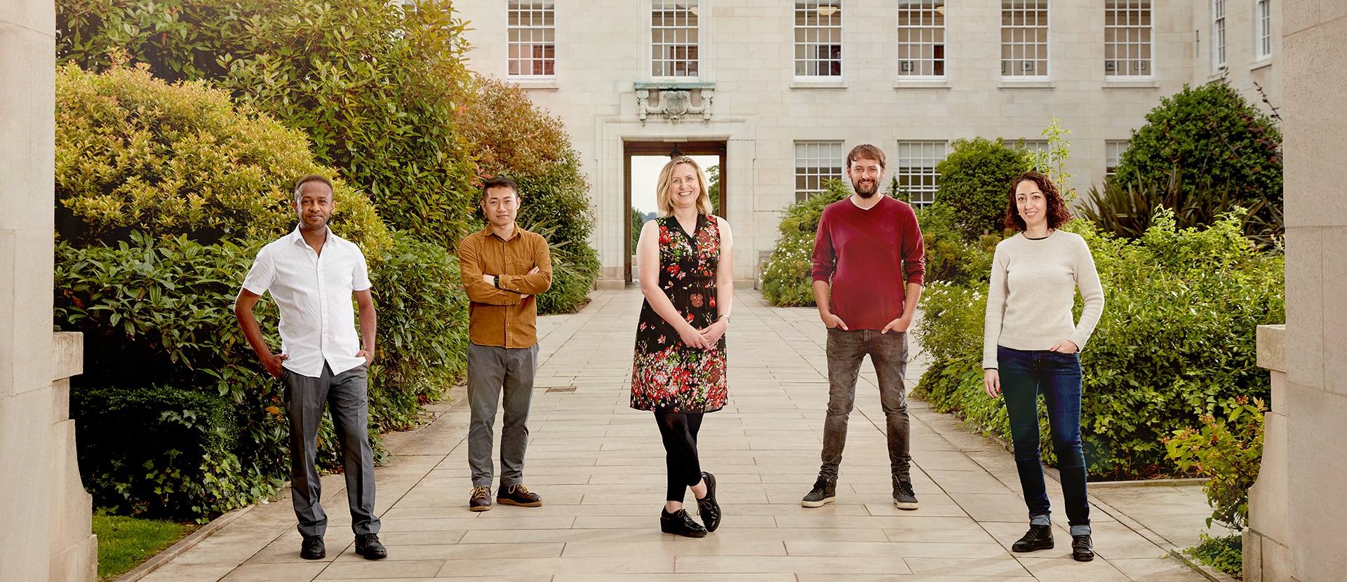 Photo of five research fellows posing in the Trent Building courtyard