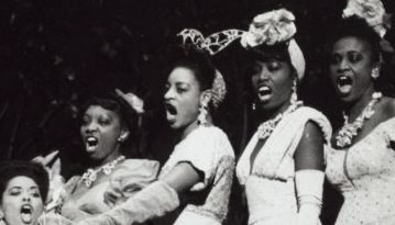 Five Black women in 1940s' costume singing