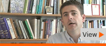 Screengrab of academic talking in front of bookshelves from Bibledex video
