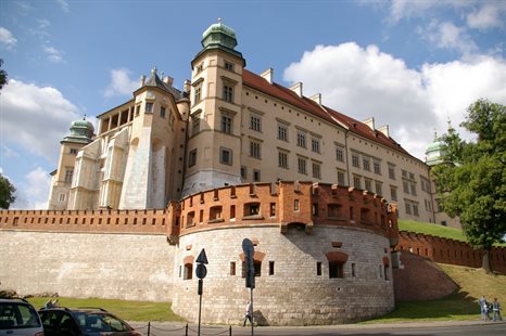 A dramatic shot of Wawel Royal Castle standing against a summer sky