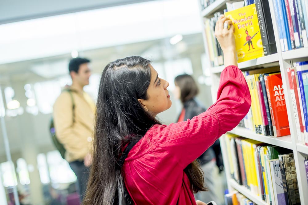 Student browsing book shelves