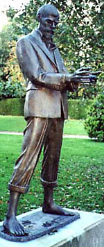 Statue of D H Lawrence, cradling a blue gentian flower in his hands