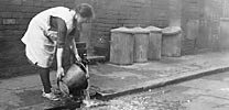 Woman collecting water from a communal water pump in 1931 (Picture The Past)