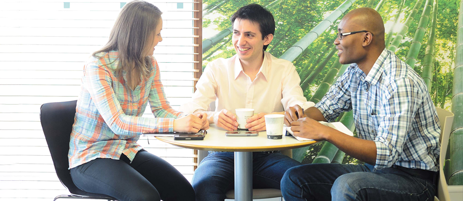 Three people sitting around a table