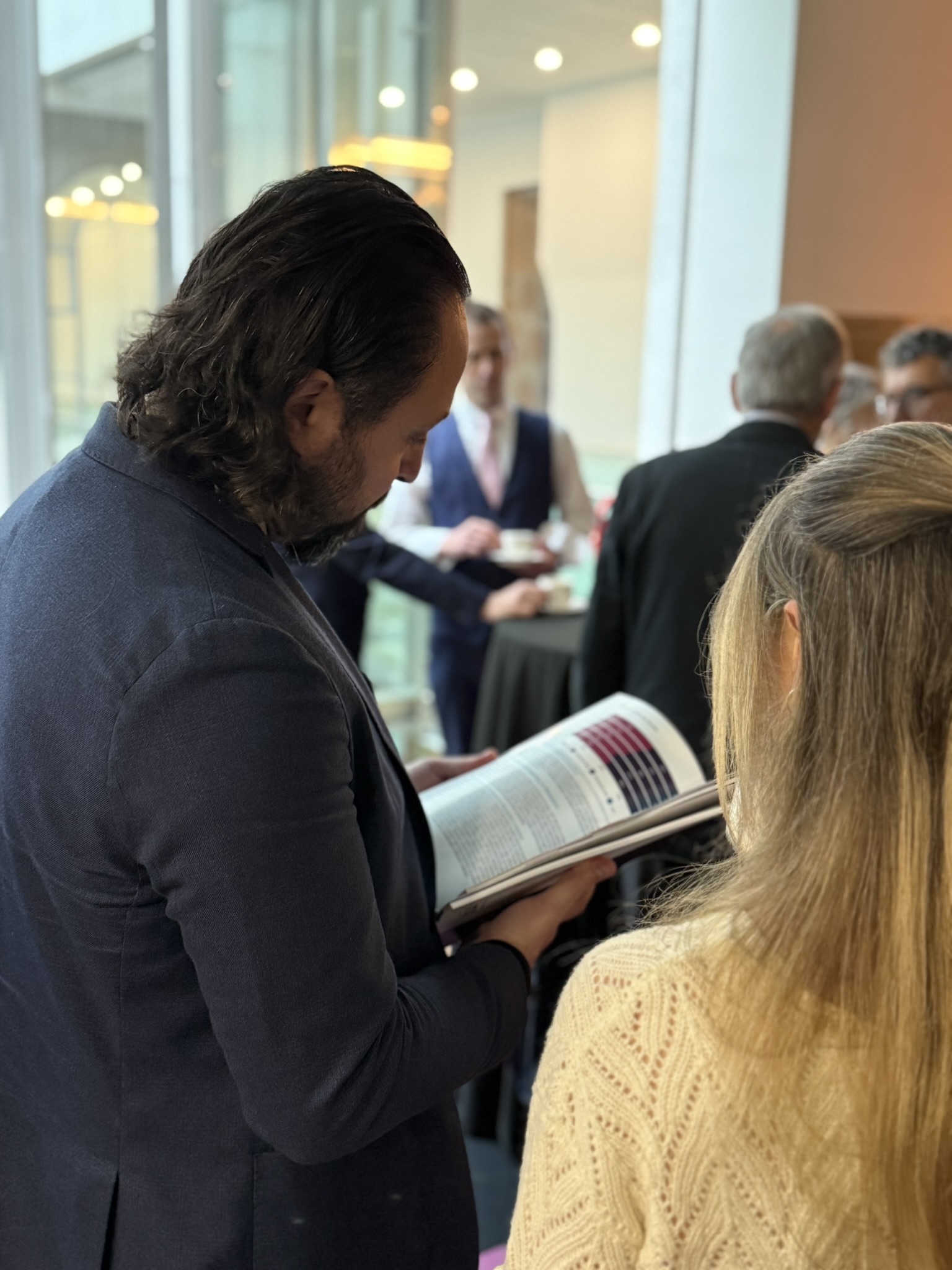 Person reading a printed copy of the RoME 2025 report