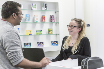 Female student wearing glasses serves a 'role playing' customer in our simulated pharmacy