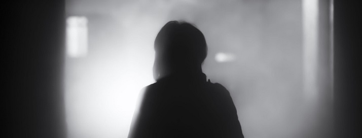 lone figure standing in room