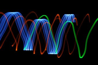 different coloured light waves on a black background