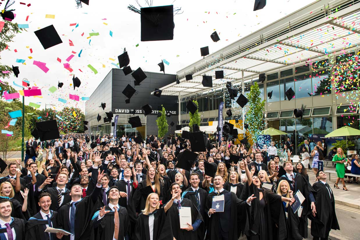A photo of graduates throwing their hats in the air