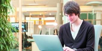 Male undergraduate student using laptop