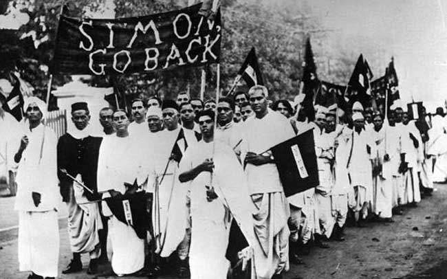 Photograph depicting protesters marching against the Simon Commission, holding a banner reading "Simon Go Back"