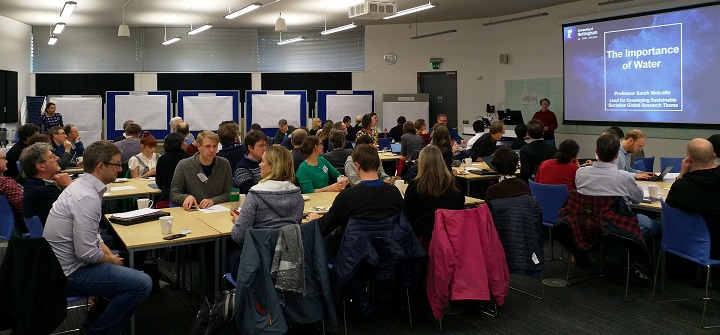 A group of students in a class room watching a presentation.