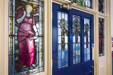 A blue door with stained glass surround