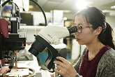 PhD student using a microscope