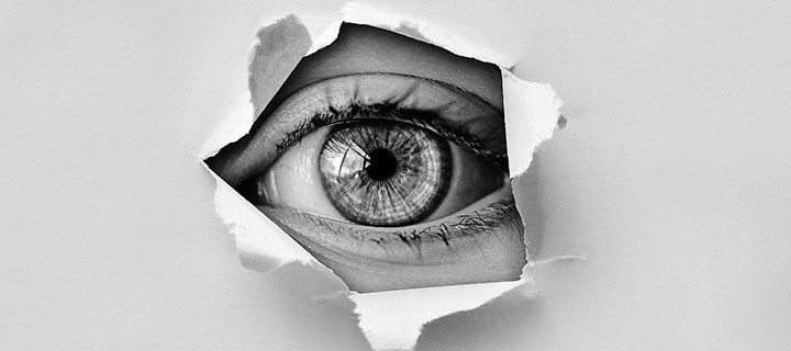 eye behind torn paper