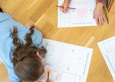 children drawing laying on the floor