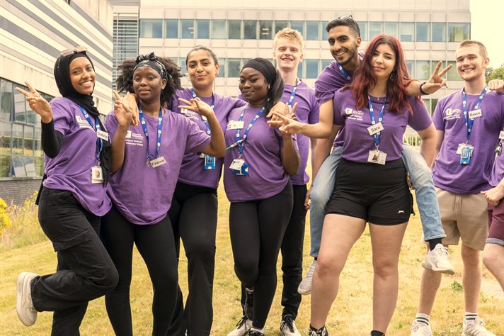A group of 8 Summer School Ambassadors in purple t-shirts posing together