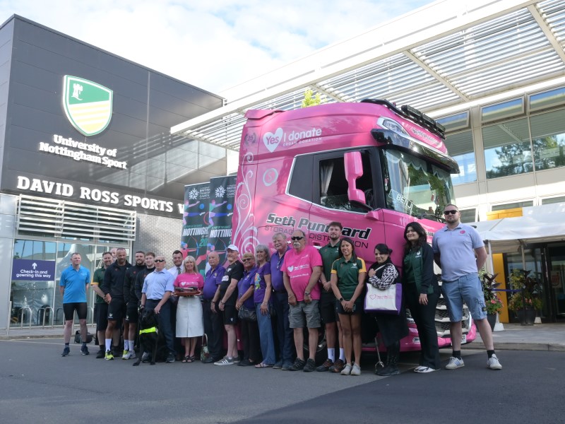 Group shot in front of David Ross Sports Village with pink Organ Donation truck