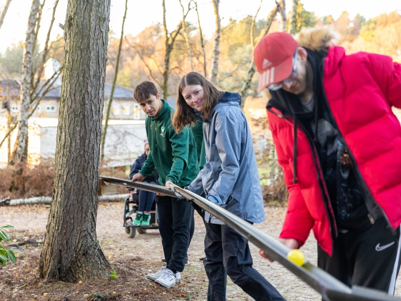 Students assist at a woodland activity session