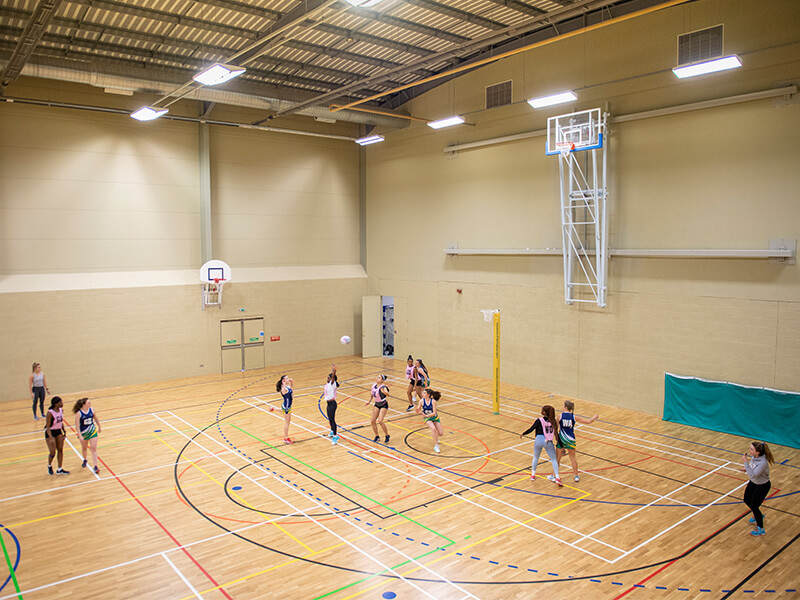A netball match taking place in the sports hall at Sutton Bonington Sports Centre.
