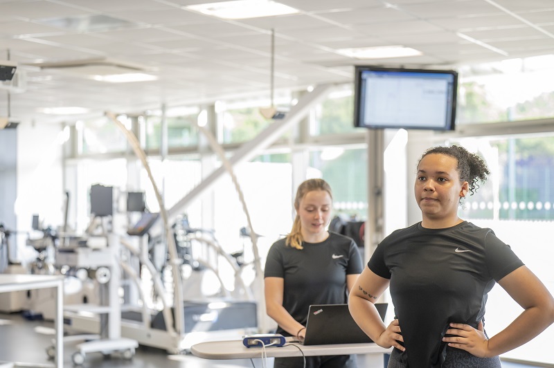 Student on laptop watches partner in Sports Injury Clinic
