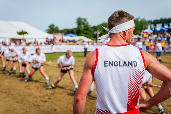 England player stands in front of tug of war competition.