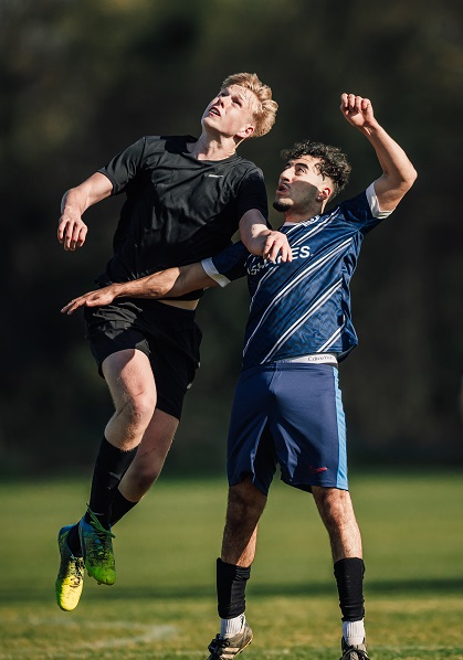 Two football players compete in the air