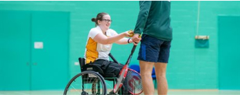 Student in a wheelchair participating in tennis