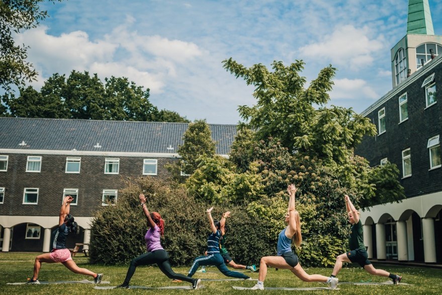 Students take a yoga class outside Rutland Hall