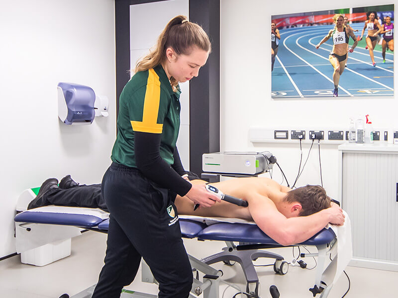 A patient receiving shockwave therapy for an injury as part of a physiotherapy treatment