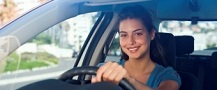 Female car driver holding steering wheel