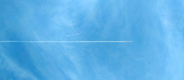 Plane travelling through blue sky