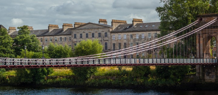 A bridge over a river with buildings in the background