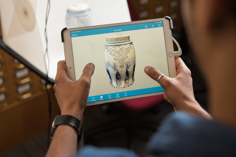 Researcher looking at image of old pot on an iPad