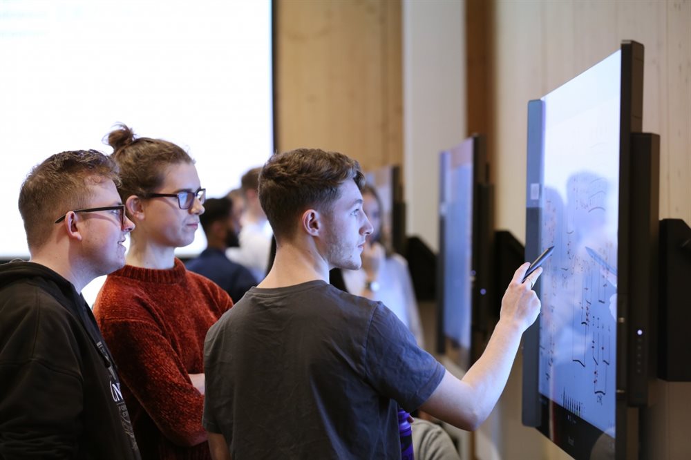 Three students working on interactive whiteboard