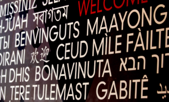 Welcome spelt in various languages - white writing on black board