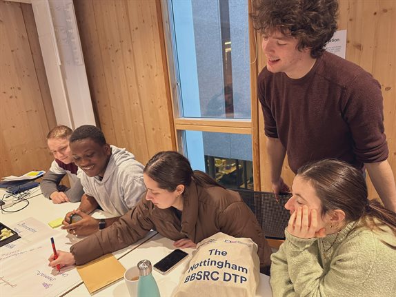 DTP students looking over shoulder of another student working on a piece of group work
