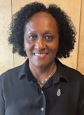 Head and shoulders photo of Veronica Pickering. Veronica is smiling and wearing a black shirt and a necklace.