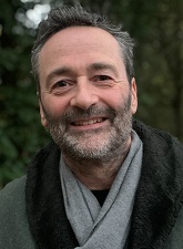 Head and shoulders photo of Colin Strong. Colin is smiling, has a beard and is wearing a grey coat with a black trim round the neck.
