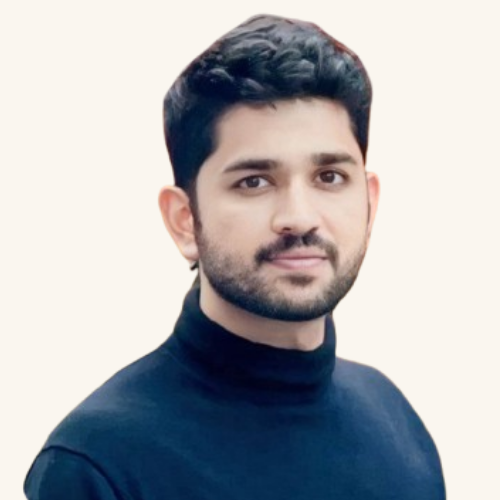 Harsh Janakkumar Shah with short dark hair and beard wearing a dark blue polo neck jumper