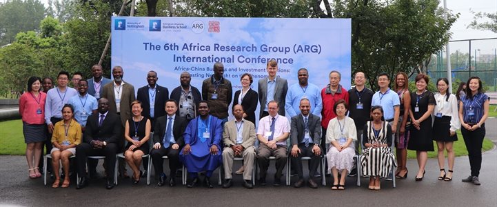 People from the Africa Research Group sat for a formal photo in front of a large banner that reads, 'The 6th Africa Research Group (AFG) International Conference'