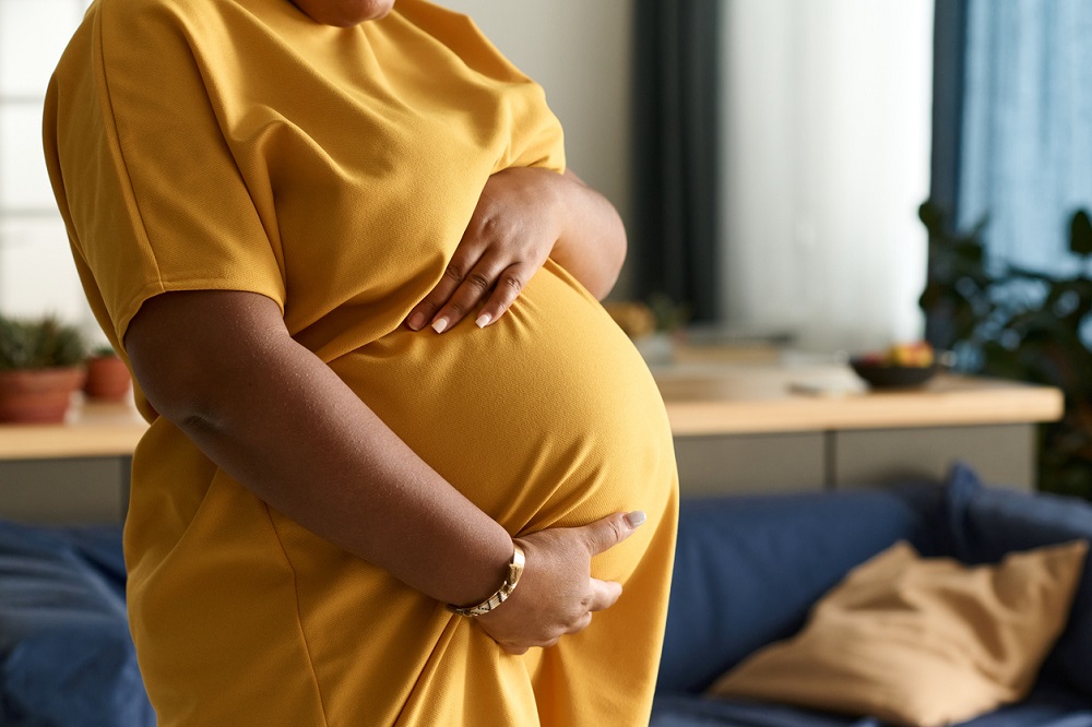A pregnant lady holding her baby bump