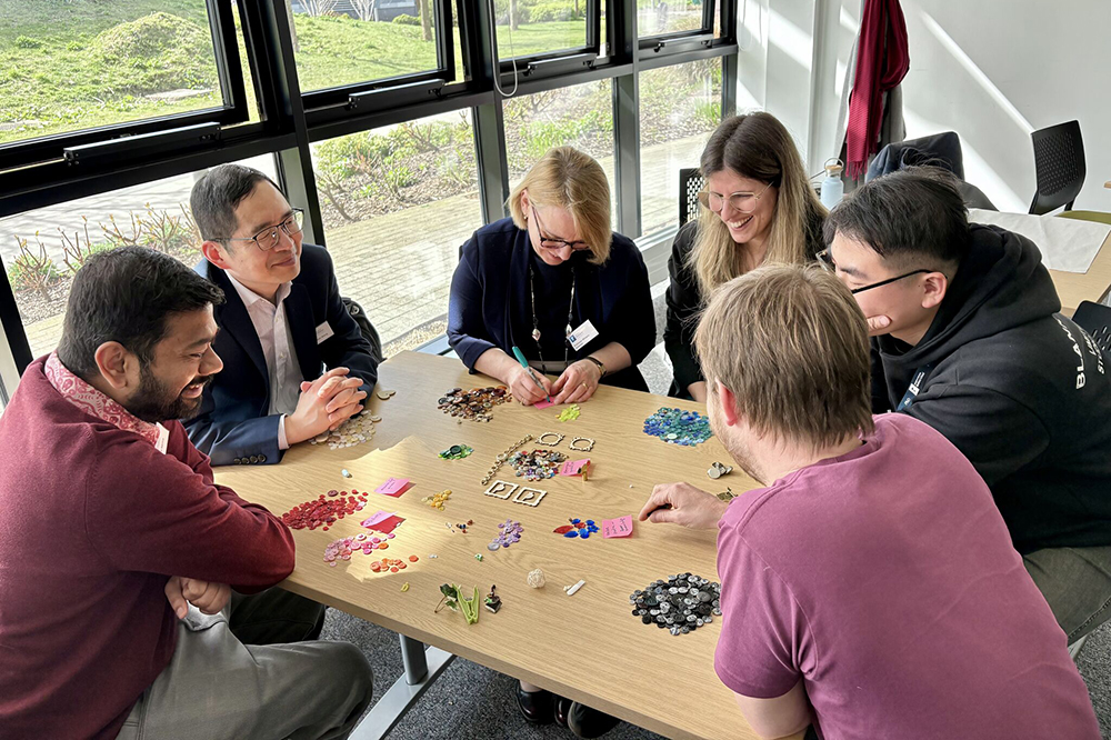 Members of the Centre for Society, Nature and Organisations sat at a table have a discussion.