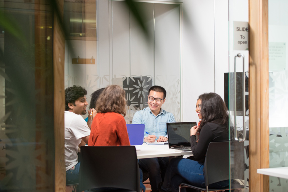 Postgraduate students using a study room in the Dearing Building, Jubilee Campus