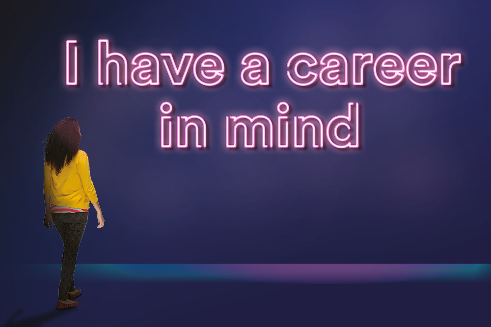 Student looking at a neon sign saying 'A career in mind'