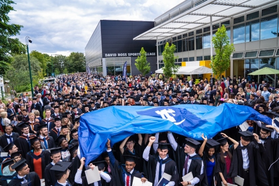 Graduating students with the university flag