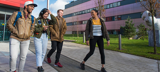 Two male and two female students walking on campus